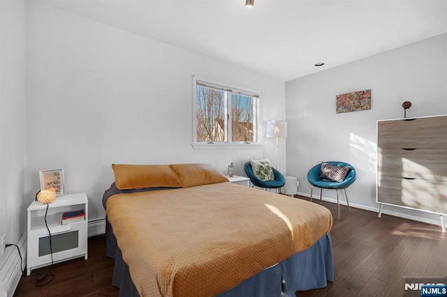 bedroom with baseboards, baseboard heating, and hardwood / wood-style floors