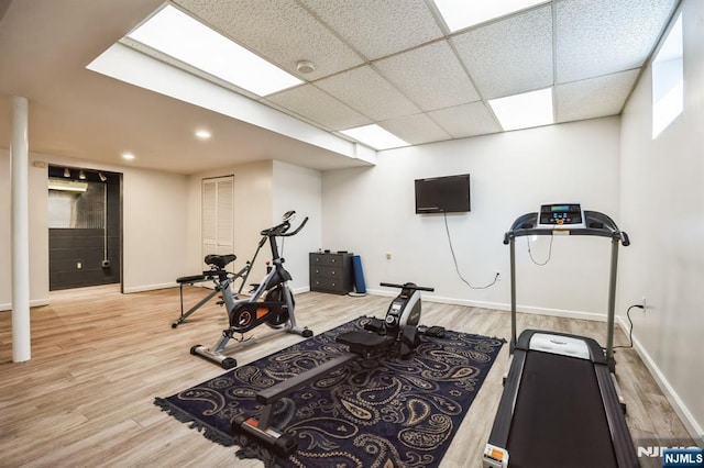 exercise area with recessed lighting, a drop ceiling, baseboards, and wood finished floors