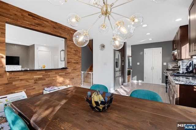 dining area with wood walls, light tile patterned floors, and recessed lighting