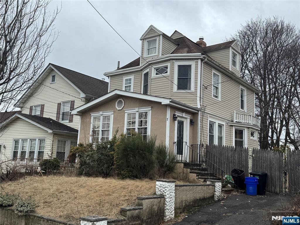 view of front of home featuring a chimney and fence