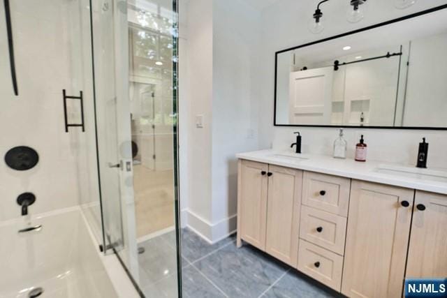 full bathroom featuring a stall shower, tile patterned floors, a sink, and double vanity