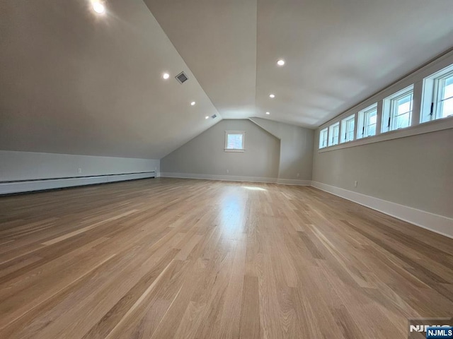 bonus room with light wood-style floors, baseboards, visible vents, and vaulted ceiling