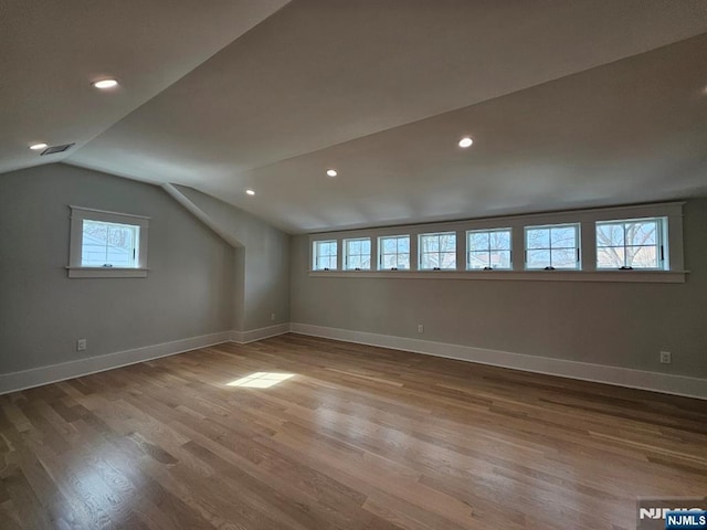 bonus room featuring lofted ceiling, baseboards, wood finished floors, and recessed lighting