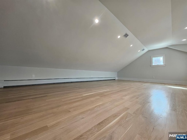 bonus room featuring baseboards, visible vents, vaulted ceiling, and light wood finished floors