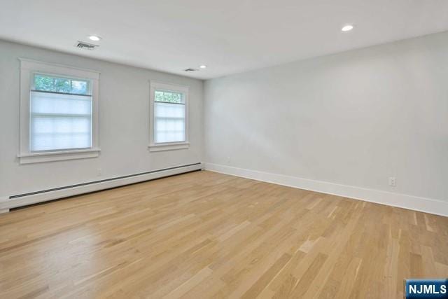 spare room with visible vents, baseboards, a baseboard radiator, light wood-type flooring, and recessed lighting