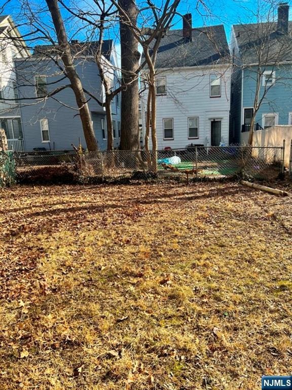 back of property with a chimney and fence