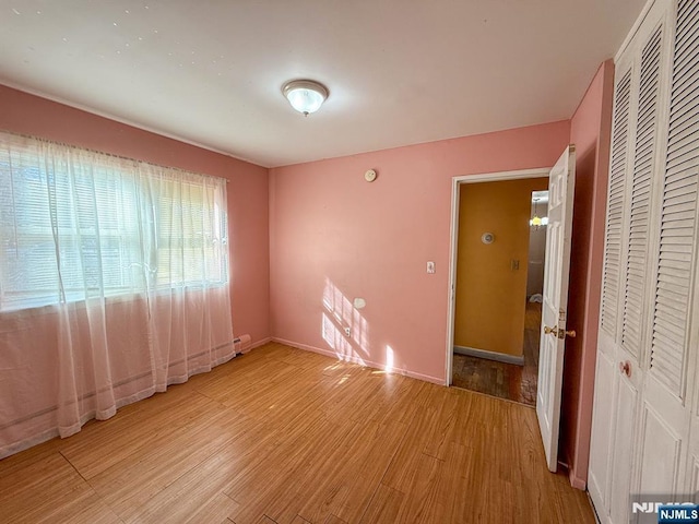 empty room featuring baseboards and light wood-style floors