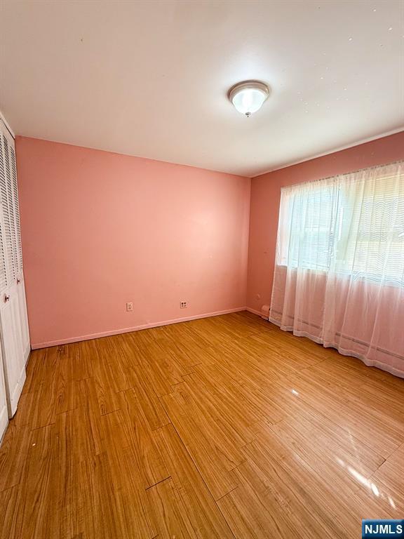 empty room featuring baseboards and light wood-style floors