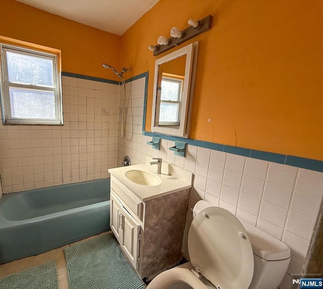 bathroom with tile patterned floors, toilet, tile walls, and a healthy amount of sunlight