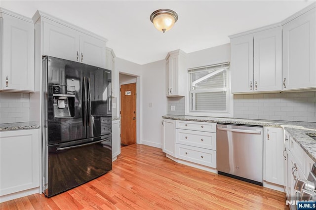 kitchen featuring light stone counters, black refrigerator with ice dispenser, light wood-style flooring, decorative backsplash, and stainless steel dishwasher