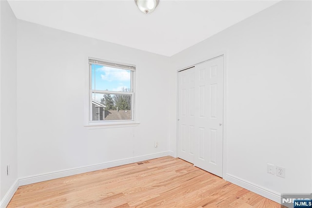 unfurnished bedroom featuring light wood finished floors, baseboards, and visible vents