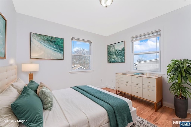 bedroom with light wood-style flooring and baseboards