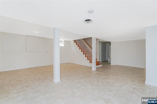 basement with baseboards and stairway