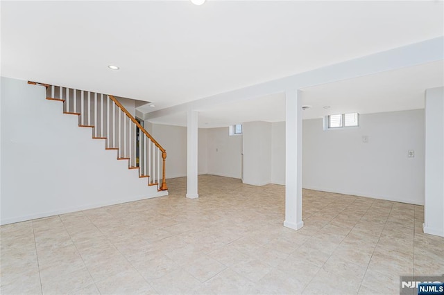 below grade area featuring stairs and baseboards