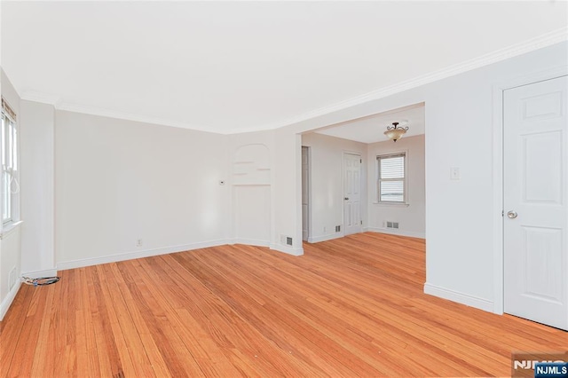 spare room with light wood-style floors, baseboards, and visible vents