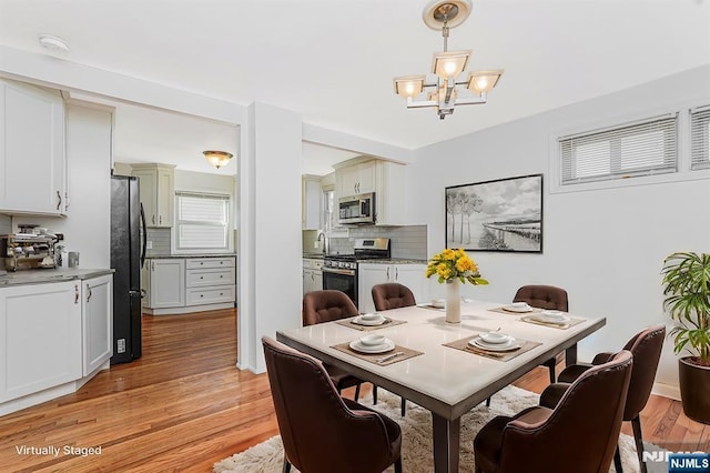 dining space with a chandelier and light wood finished floors