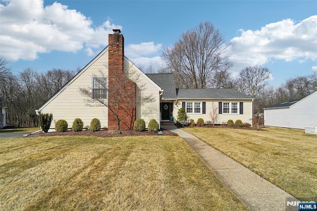 view of front of home featuring a front yard and a chimney