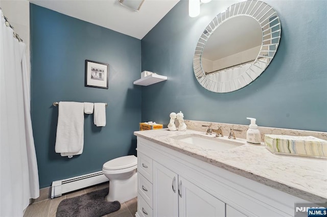 bathroom featuring a baseboard heating unit, vanity, toilet, and baseboards