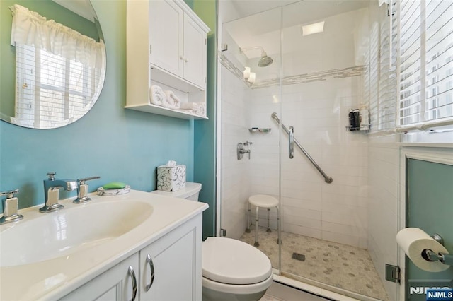 full bathroom featuring vanity, a shower stall, and toilet