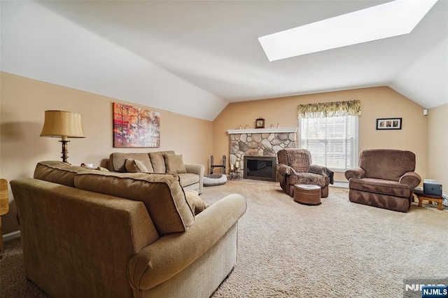 carpeted living room with vaulted ceiling with skylight, a stone fireplace, and baseboard heating