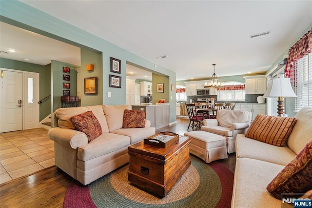 tiled living room with a chandelier, recessed lighting, and visible vents