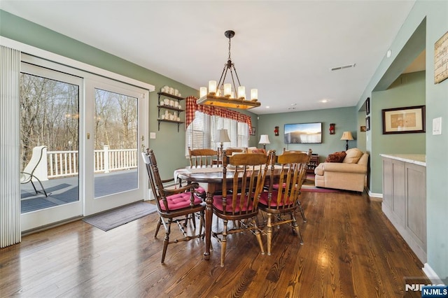 dining room with an inviting chandelier, visible vents, and dark wood-style flooring