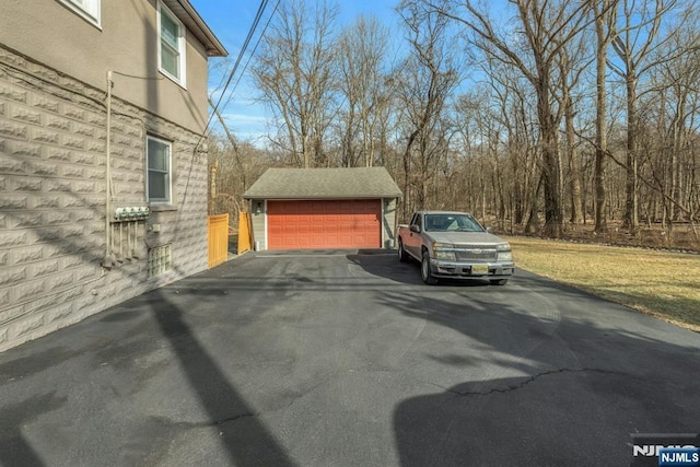 view of side of property featuring an outbuilding, a detached garage, and stucco siding