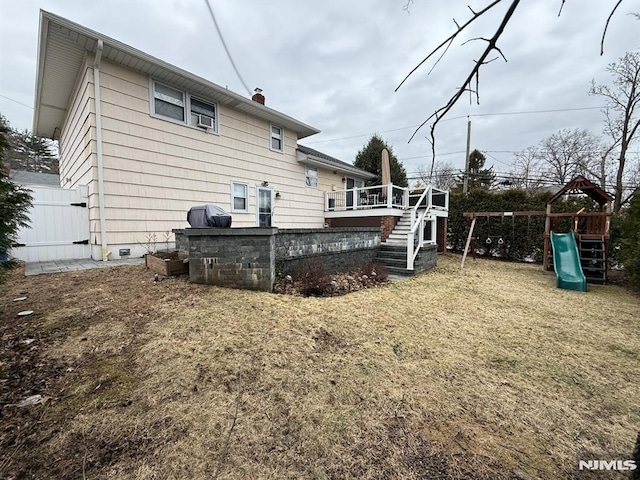 back of house featuring a playground, a chimney, and stairs