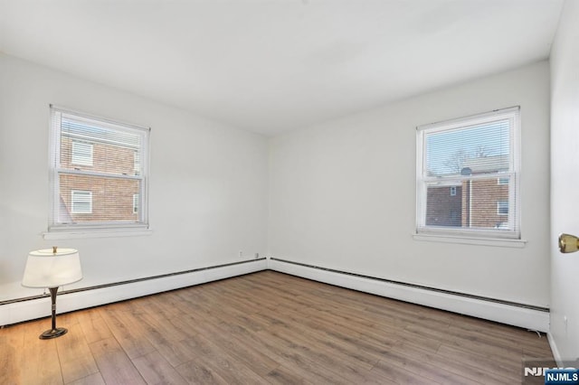 unfurnished room featuring a healthy amount of sunlight and wood finished floors