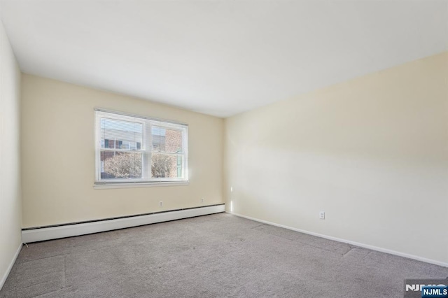 spare room with baseboards, a baseboard heating unit, and carpet flooring