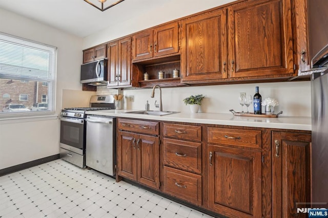 kitchen featuring tasteful backsplash, stainless steel appliances, a sink, and light countertops