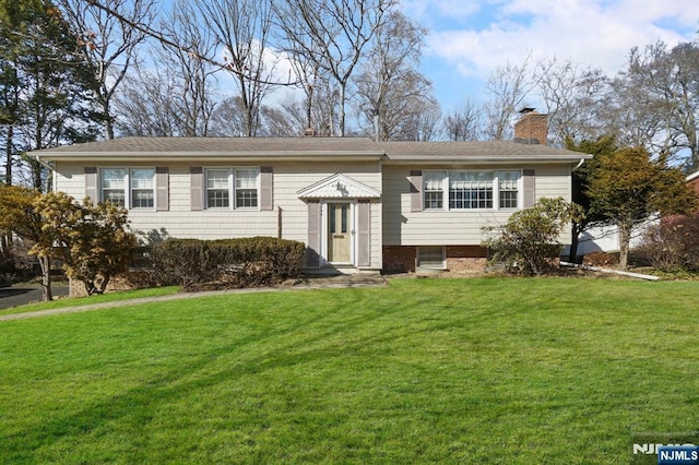 bi-level home featuring a chimney and a front lawn