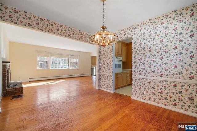 unfurnished living room featuring a baseboard radiator, light wood-style flooring, and wallpapered walls