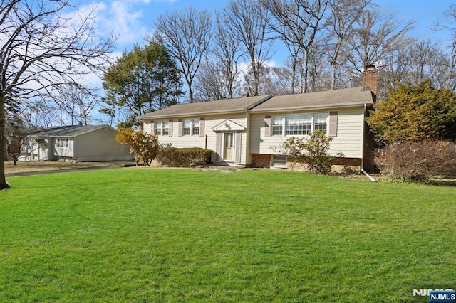 bi-level home featuring a front yard and a chimney