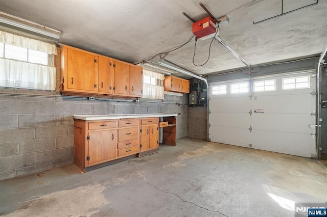 garage featuring concrete block wall and a garage door opener