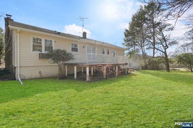 rear view of property featuring a deck, a yard, and a chimney