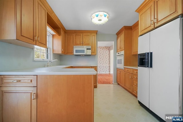 kitchen with white appliances, light floors, a sink, and light countertops