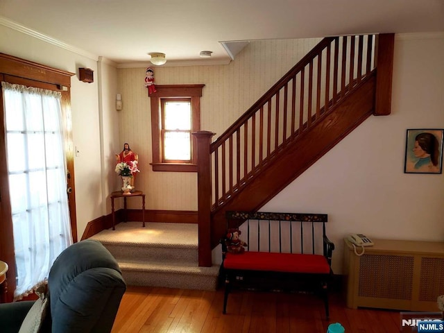 staircase featuring plenty of natural light, baseboards, radiator heating unit, and hardwood / wood-style floors