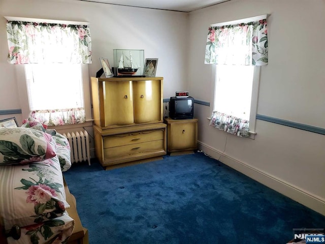 carpeted bedroom featuring radiator heating unit and baseboards