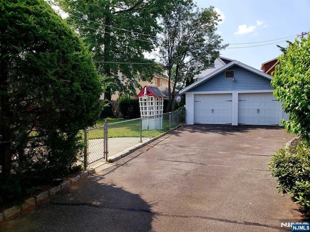 detached garage with fence and a gate