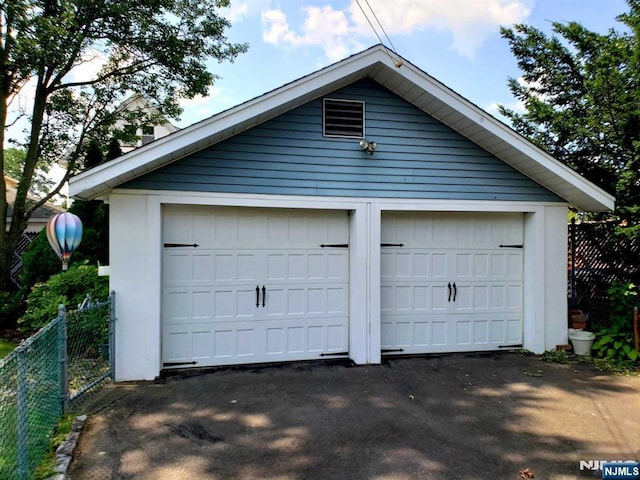 detached garage featuring fence