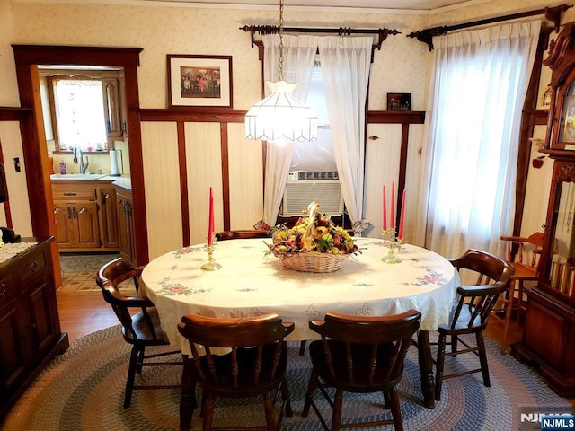 dining space featuring wallpapered walls, cooling unit, and dark wood-style flooring