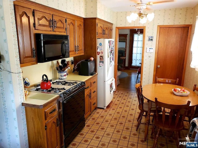 kitchen featuring black appliances, brown cabinetry, light countertops, and wallpapered walls