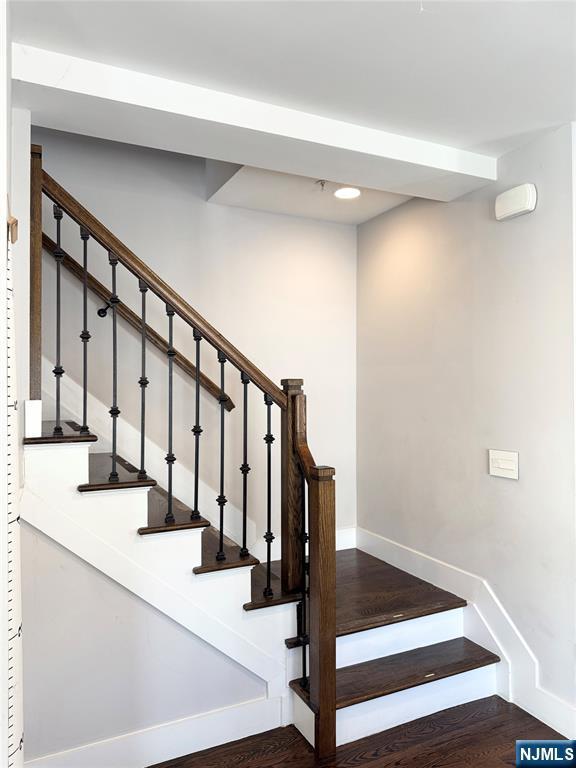 stairway featuring baseboards and wood finished floors