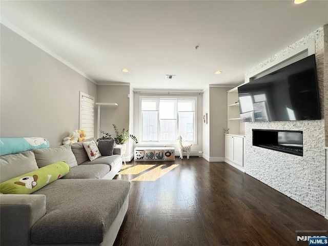 living area featuring dark wood finished floors, visible vents, ornamental molding, a glass covered fireplace, and baseboards