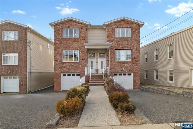 view of front of house with driveway and brick siding