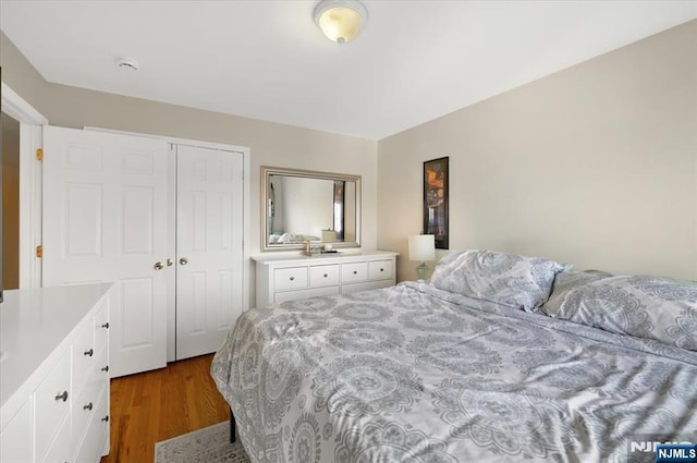 bedroom with dark wood-style flooring and a closet