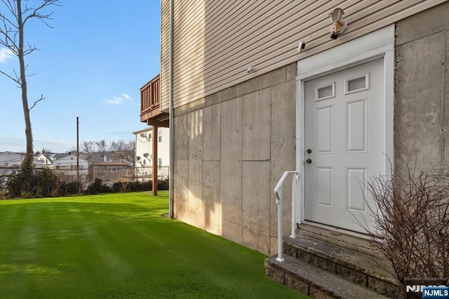 doorway to property featuring a lawn