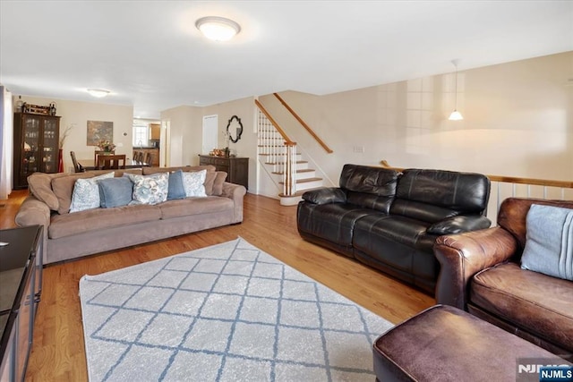 living room with stairs and wood finished floors