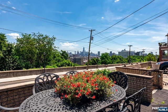 view of patio / terrace featuring outdoor dining area and a city view